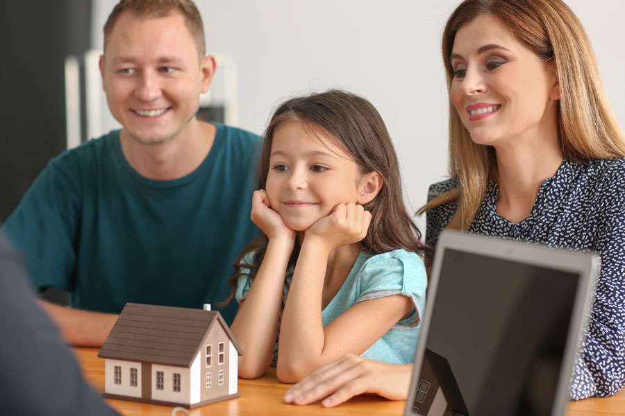 Happy family with real estate agent in office