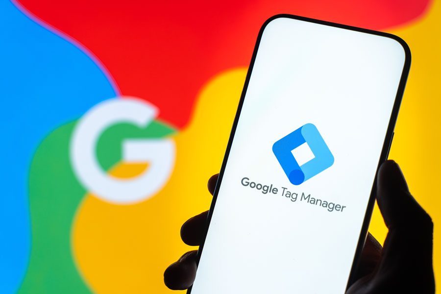 Google Tag Manager logo is displayed on the screen of a smartphone,